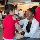Alt text: image of student doctor performing an exam on a young boy